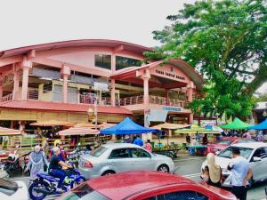 a building with cars parked in front of a street at Cozii Home Marang in Marang +26 photos