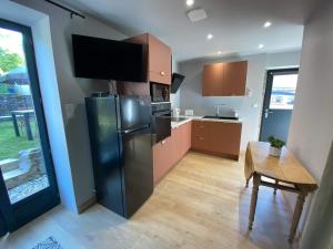 a kitchen with a stainless steel refrigerator and a table at Maisonnette avec jardin in Chamilly