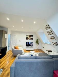 Una sala de estar con un sofá azul y un televisor. en Southsea Modern Apt, en Southsea