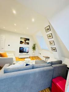 Una sala de estar con un sofá azul y una escalera. en Southsea Modern Apt, en Southsea 59 fotos más
