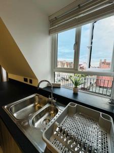 cocina con fregadero y ventana con vistas en Southsea Modern Apt, en Southsea