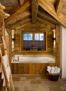 uma grande casa de banho em madeira com uma banheira num quarto em Chaletdorf Auszeit em Hüttschlag