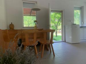 Una cocina con mesa y sillas y un refrigerador. en Mazsola, en Bélapátfalva
