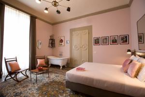 a bedroom with a bed, chair and a painting on the wall at AdAstra Suites in Florence