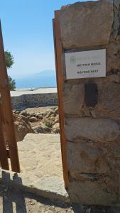 a sign on the side of a stone wall at Nisyros Nest in Nikiá