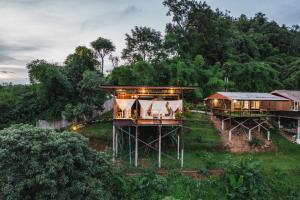 a tree house in the middle of a field at Hubkhaosawan Homestay in Ban Thung Phan Ha