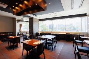 福岡市にある博多エクセルホテル東急のテーブルと椅子と大きな窓のあるレストラン