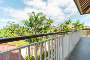 a balcony with a view of palm trees at Villa GMT Canggu - By Bali Lyfe Venture in Canggu