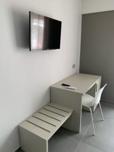 a desk with a chair and a tv on a wall at B&B The Princess accanto all'Aeroporto di Salerno-Costa D'Amalfi in Bellizzi +55 photos