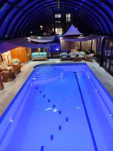 a large swimming pool with blue lighting in a building at Deluxe Villa Coast River Sarajevo in Visoko