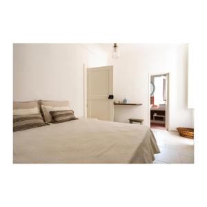 a white bedroom with a bed and a table at Mava' - Splendida struttura nel centro storico di Fasano in Fasano
