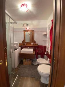 un baño con inodoro y lavabo en Hostdomus - Grand Villard Suite, en Sauze dʼOulx