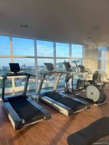 a gym with cardio machines and a large window at Casa Mira Guadalupe Harmony Home Cebu City in Cebu City
