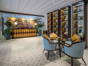 a lobby with two chairs and a table and a painting at Little Residence - A Boutique Hotel & Spa in Hoi An
