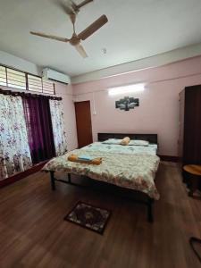 a bedroom with a bed and a ceiling fan at RESTFUL HEAVEN HOMESTAy in Nunmāti