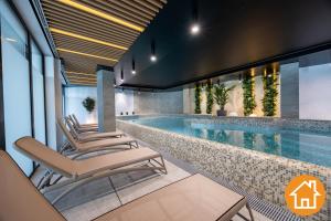 an image of a swimming pool with chairs around it at Apartamenty Baltic Waves - visitopl in Międzyzdroje