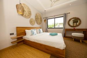 una camera da letto con un letto grande e uno specchio di Anse Boudin Chalets a Anse Possession