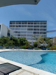 una piscina di fronte a un grande edificio di Hermoso Depto en Condominio Astoria ad Acapulco