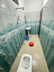 BarkotHotel Rest and Bite的一间有小便和红色盖子的浴室