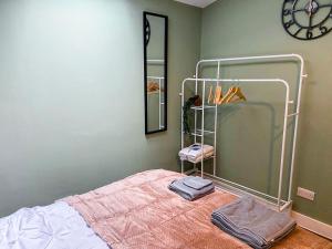 a bedroom with a bed with a mirror and a rack at Stylish Bungalow upto 6 guests in Caversham