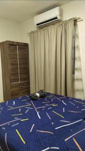 a bedroom with a bed and a air conditioner at Mactan Guesthouse in Cogon