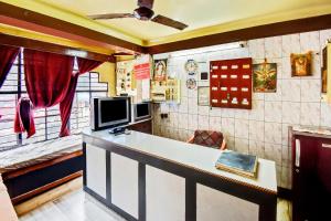 瓜廖尔Hotel O Plaza Lodge的一间客房配有书桌和电视的客房