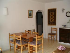a dining room with a wooden table and chairs at La Parata Apartments in Moj&aacute;car