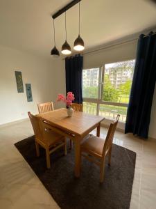 a dining room table with chairs and a vase with flowers at Madinaty B12 Guesthouse Shared Apartment - Garden View in Madinaty
