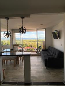 un salon avec un canapé noir et une table dans l'établissement Apartamento de verano, à San Rafael