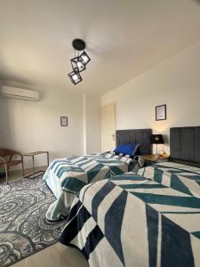 a bedroom with two beds and a table and a lamp at Madinaty B12 Guesthouse Shared Apartment - Garden View in Madinaty