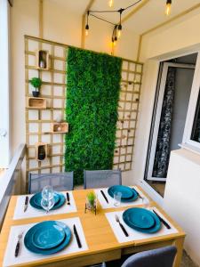 une salle à manger avec une table et un mur vert dans l'établissement Studio Cabine Piscine-Clim-Parking-Plage200m, à Valras-Plage 3 autres photos