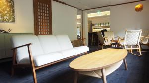 ein Wohnzimmer mit einer weißen Couch und einem Tisch in der Unterkunft Hoo!Hoo! in Ono