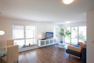 - un salon avec un canapé et une télévision ainsi que quelques fenêtres dans l'établissement Casa Fortuna Bodensee, à Lindau-Bodolz