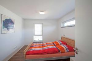 Lindau-BodolzにあるCasa Fortuna Bodenseeのベッドルーム1室(カラフルな毛布付きのベッド1台付)