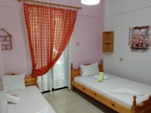 two beds in a room with a window at Villa ΝOSTALGΙΑ in Kokkino Nero