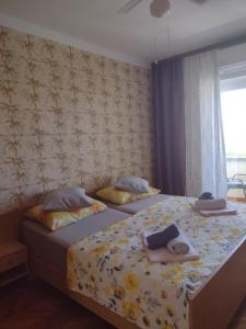 two beds in a bedroom with towels on them at APARTMANI ALEN in Dinjiška