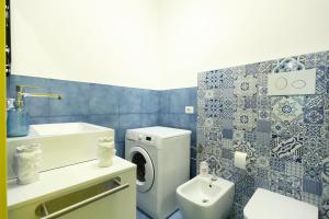 a bathroom with a washing machine and a sink at Sul Mare Apartment in Capo dʼOrlando
