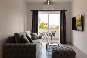 a living room with a couch and a large window at Apartment Salvia in Kaštela