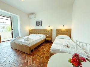 una camera con due letti e un tavolo con fiori di Vizion Hotel a Shkodër