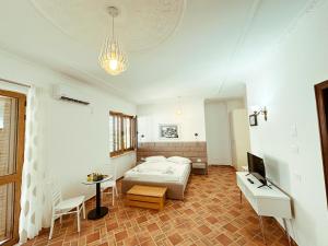 una camera da letto con un letto, un tavolo e una TV di Vizion Hotel a Shkodër
