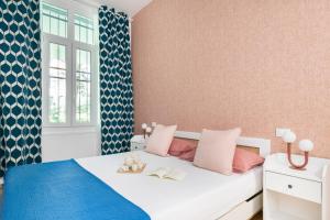sypialnia z białym łóżkiem z różowymi i niebieskimi akcentami w obiekcie Easylife - Splendido bilocale immerso nel verde in zona Brera w Mediolanie