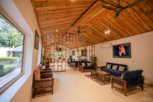 a living room with a wooden ceiling at La Perle River Resort By Excel Hotels & Resorts in Rāmnagar