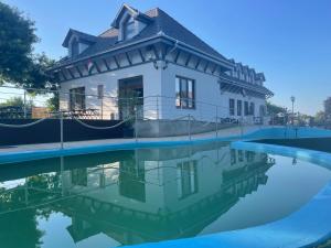 a house with a reflection in a pool of water at Reneszánsz Vendégház in Debrecen