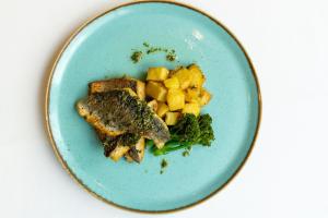 a blue plate of food with fish and vegetables at Aloft London Excel in London