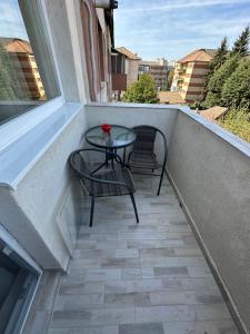 a small balcony with a table and chairs on it at Desire Loft in Alba Iulia