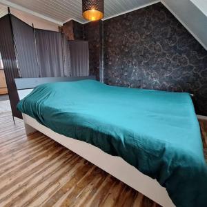 een slaapkamer met een groot bed en een groen dekbed bij Just-ed Weeze in Weeze
