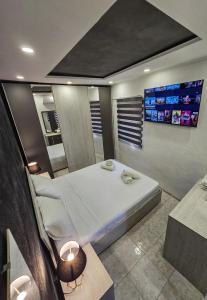 una camera da letto con un grande letto bianco e due monitor di Sunshell luxury apartment a Lija