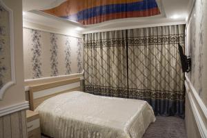 a bedroom with a bed and a dresser at Hotel Olimp in Orenburg
