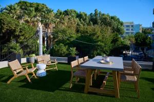 a table and chairs on a lawn with trees at Monarco Executive Rooms in Rhodes Town +75 photos