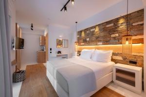 a bedroom with a white bed and a stone wall at Evia Silence lighthouse in Boufalo